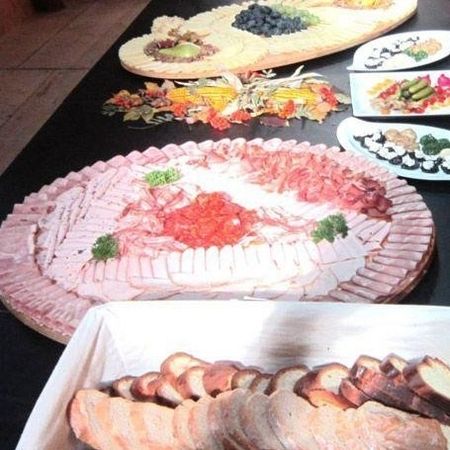 Große Aufschnittplatte mit Wurst, Schinken und Käse, daneben Brotkorb mit geschnittenem Bauernbrot.